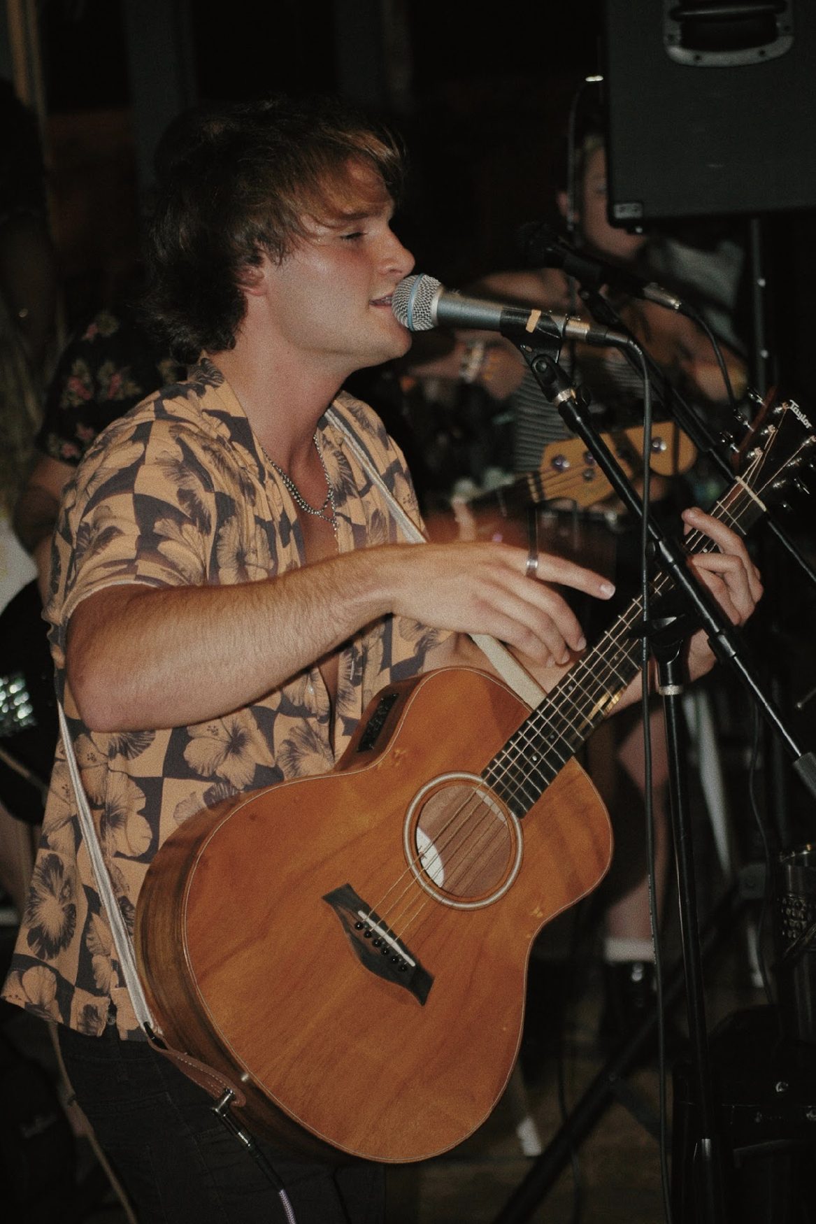 Marco playing acoustic at a night show