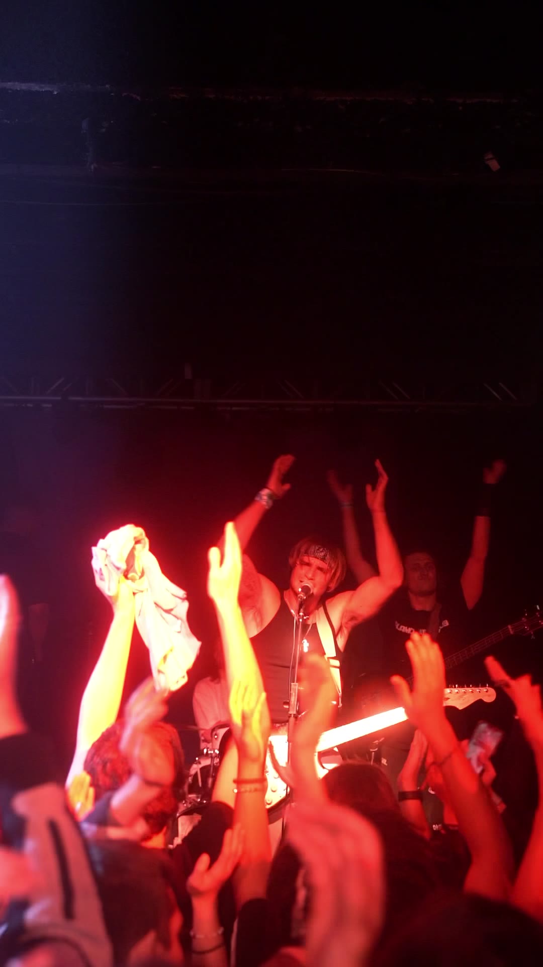 Marco with arms up over a crowd of raised hands